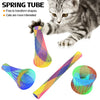A kitten interacts with colorful spring tube toys, showing various shapes and colors.