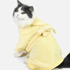 A fluffy gray and white cat wearing a yellow multi-purpose pet bath robe.