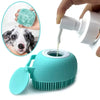 A hand is squeezing a green silicone pet grooming brush, next to a teal silicone pet bather tool.