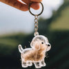 Un perro de silicona de dibujos animados claro con pelo esponjoso, unido a un llavero plateado.