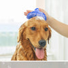 A hand is applying a blue rubber grooming brush to the head of a dog.