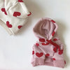 Sudadera rosa con estampado de corazón rojo y puños de ribete sobre fondo blanco.