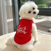 Un caniche blanc portant un débardeur rouge avec du texte blanc sur la poitrine.