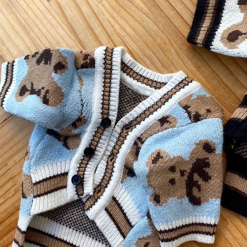 Suéter de perro tejido beige y azul con estampado de oso marrón.