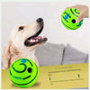 Un golden retriever regarde une balle en caoutchouc verte, avec une autre balle verte à proximité.
