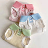A collection of pink, blue, and cream knitted dog t-shirts with lapel collars.