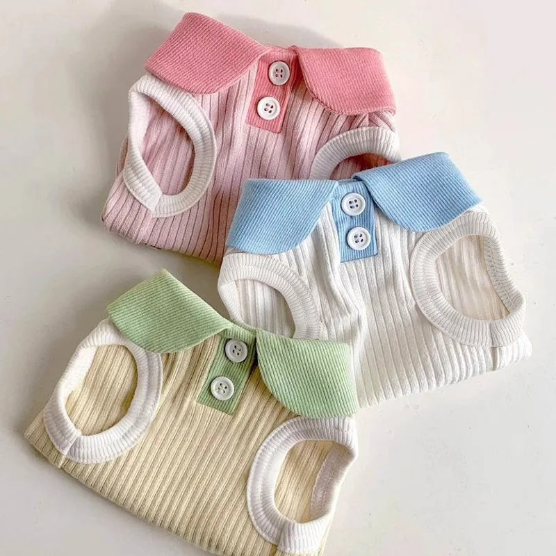 A collection of pink, blue, and cream knitted dog t-shirts with lapel collars.