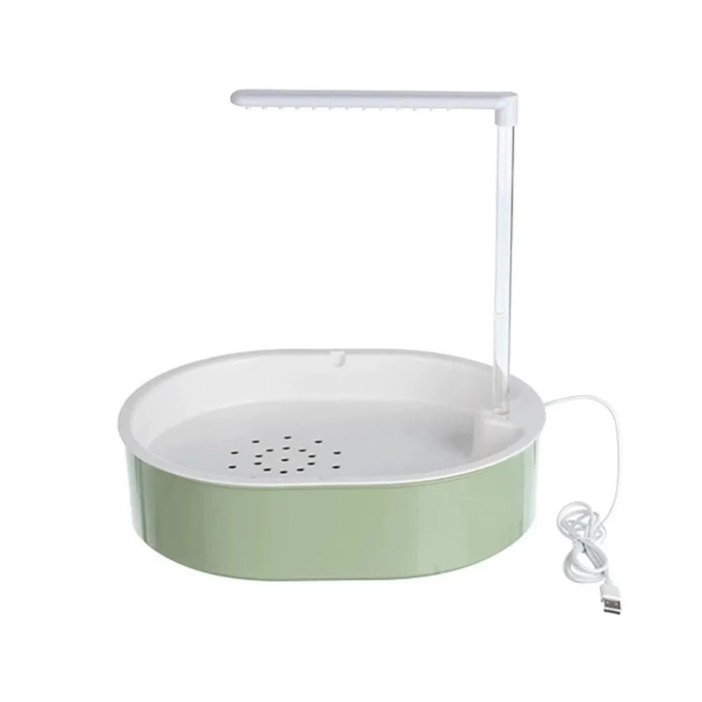 A white automatic bird bathtub with a clear resting stick and power cord.