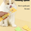 Eine Hand verwendet einen gelben Esslöffel, um sanft Futter in den Mund einer Katze zu drücken.