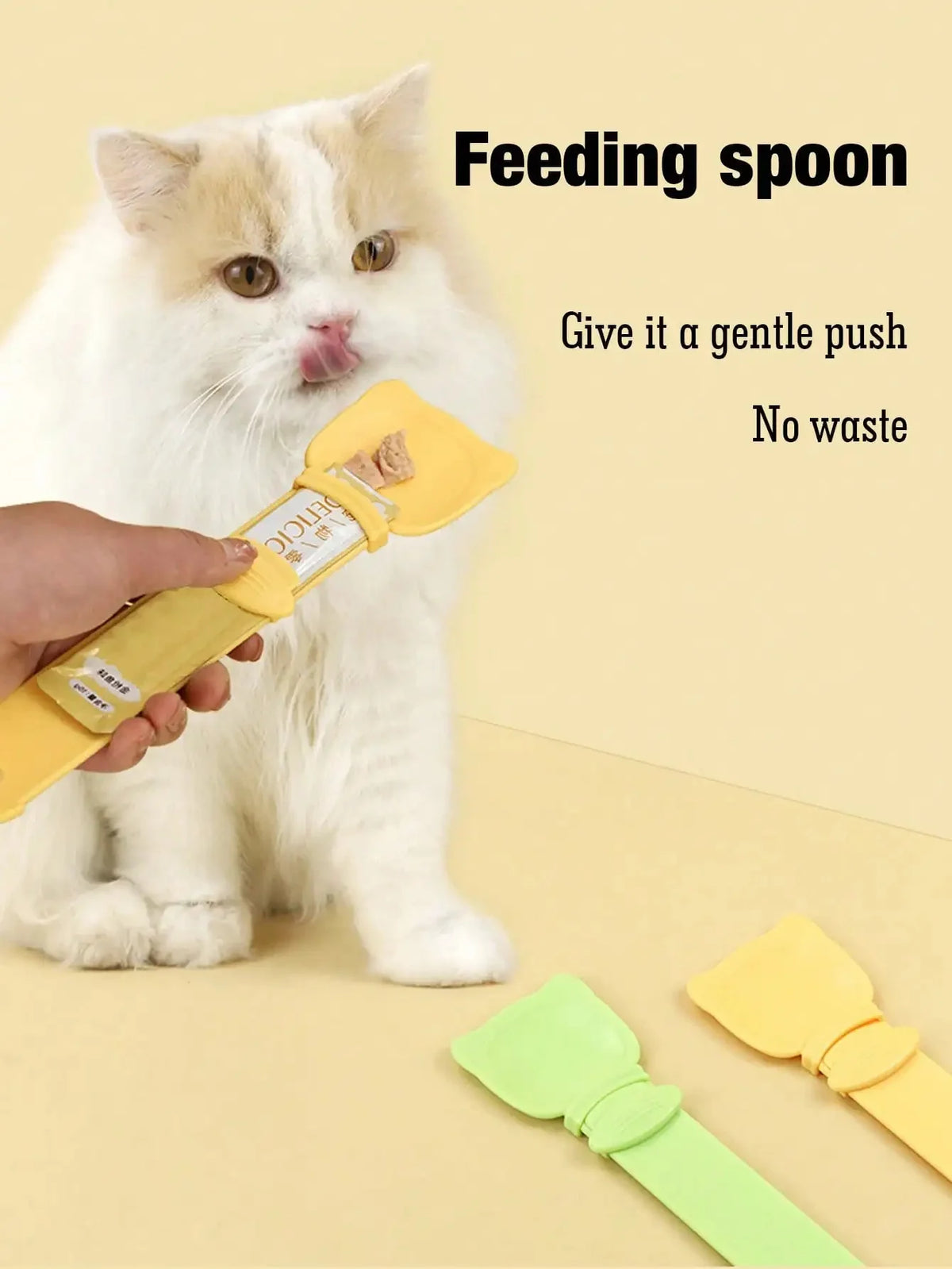 Eine Hand verwendet einen gelben Esslöffel, um sanft Futter in den Mund einer Katze zu drücken.