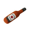 An orange plush bottle toy shaped like a bourbon whiskey bottle with a black cap and a label.