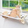Ein flauschiger orange und weißer Kater entspannt in einem natürlichen Holzfenster-Hängebett.