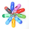 A collection of colorful capsule-shaped dog poop bag dispensers with carabiner clips.