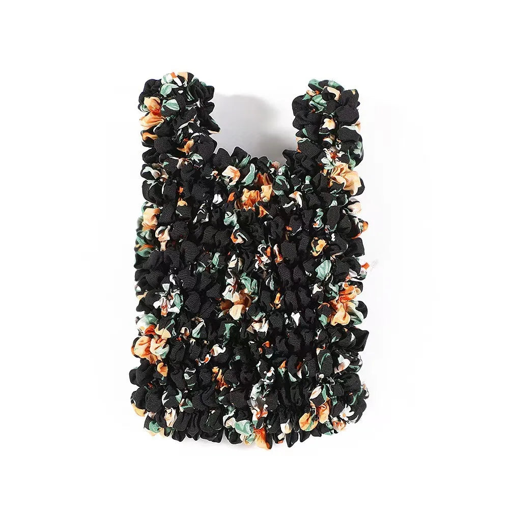 A reusable foldable bubble shopping bag made of black fabric with floral accents.