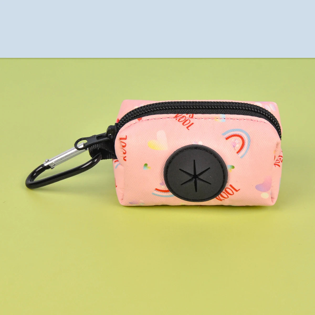 A pink zippered pouch designed as a stylish dog poop bag holder rests on a light green surface.
