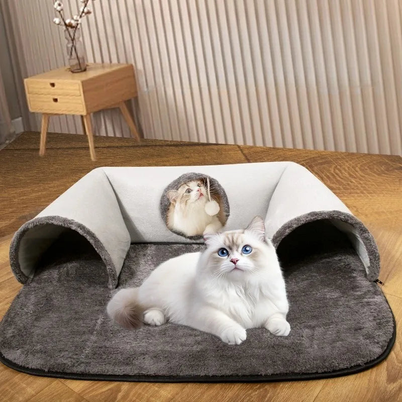 Ein flauschiger weißer Kater entspannt sich in einem grauen U-förmigen Katzenbett auf einem Holzfußboden.