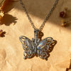 Silver butterfly pendant necklace resting on crumpled brown paper