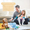 A man is training a dog using a blue and yellow sniffing mat on a gray rug.