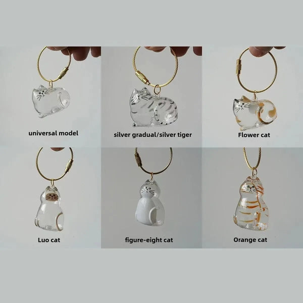 A collection of silver and glass cat-themed necklaces and pendants for pet hair storage keychains.