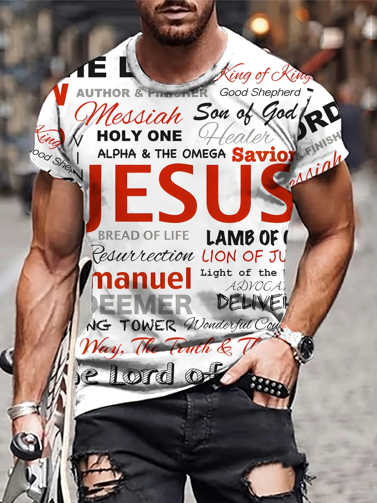 A man wearing a white t-shirt with various religious words printed on it, standing outdoors.
