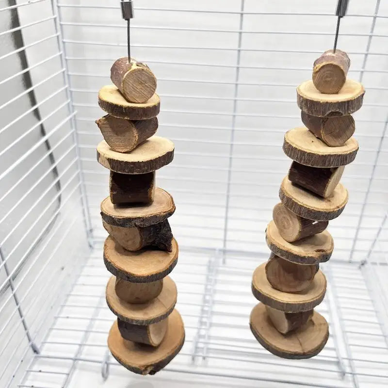 Vertikaler Stapel natürlicher Holzknabberspielzeuge für kleine Nagetiere in einem Drahtkäfig.