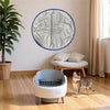 A circular silver and blue replacement liner for a self-cleaning litter box hangs on a wall.