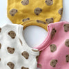 A set of two toddler vests featuring a cartoon bear print in yellow and pink colors.