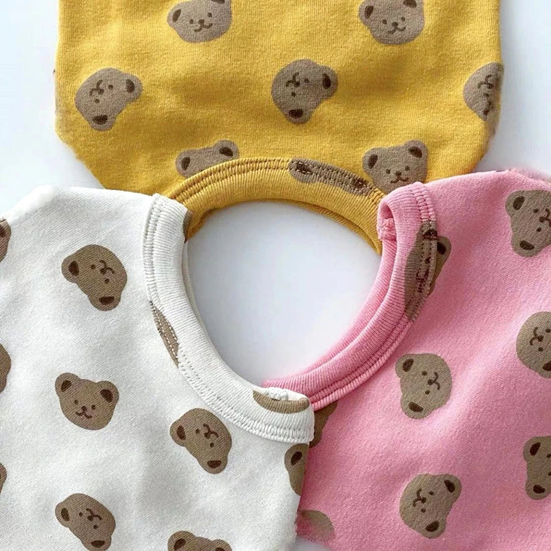 A set of two toddler vests featuring a cartoon bear print in yellow and pink colors.
