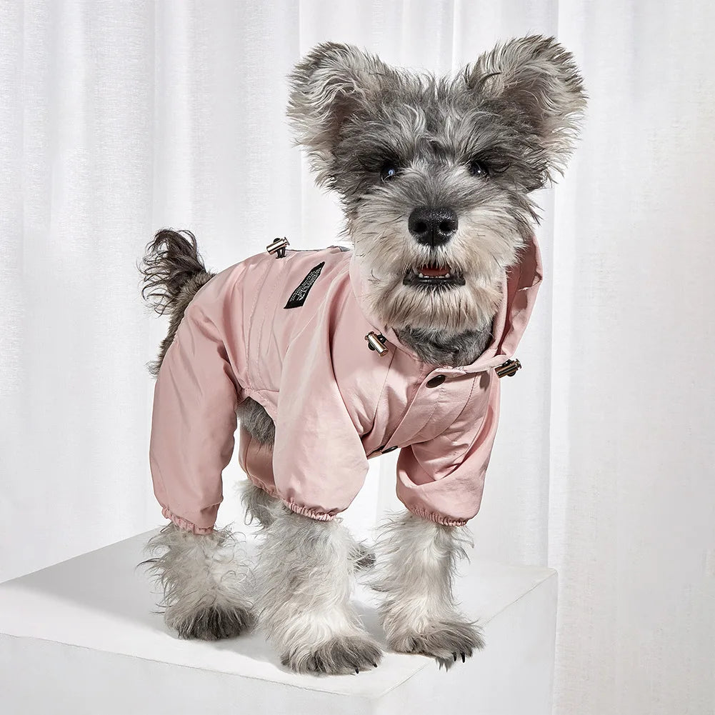 A fluffy gray dog wearing a pink waterproof reflective raincoat and jumpsuit.