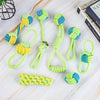 A collection of green and blue rope ball dog toys with various knots and shapes displayed on a white wooden surface.