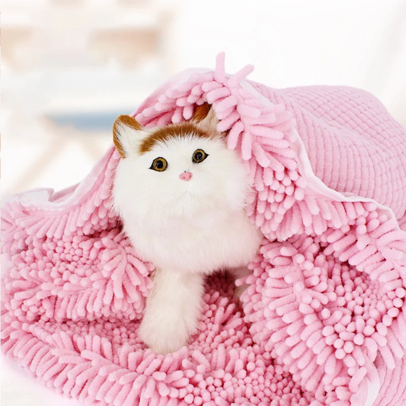 A fluffy white kitten is nestled inside a pink ultra-absorbent chenille pet bath towel.