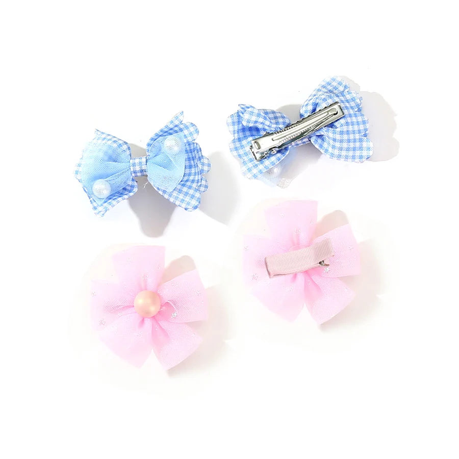 Two light blue gingham bow clips and two pink fabric flower clips for pet grooming.