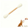 A wooden cotton swab shaped catnip toy is being used by a hand to interact with a small orange kitten.