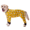 A golden retriever wearing a yellow jumpsuit with a cartoon animal print featuring various small animals.