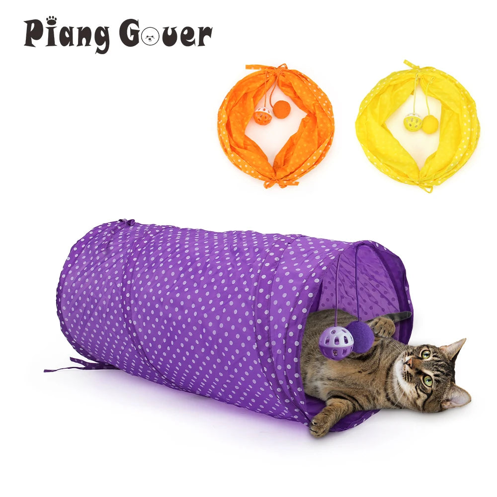 An orange collapsible cat tunnel play tube with hanging balls is shown next to a purple fabric tube and a cat.