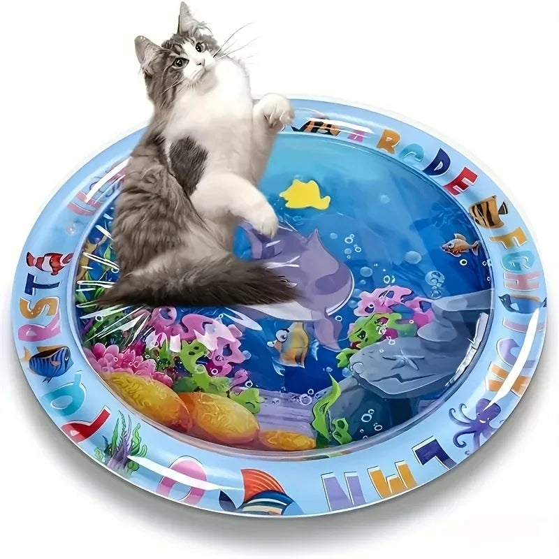 Un chaton gris et blanc joue sur une assiette en plastique bleue remplie de poissons colorés et d'éléments aquatiques.