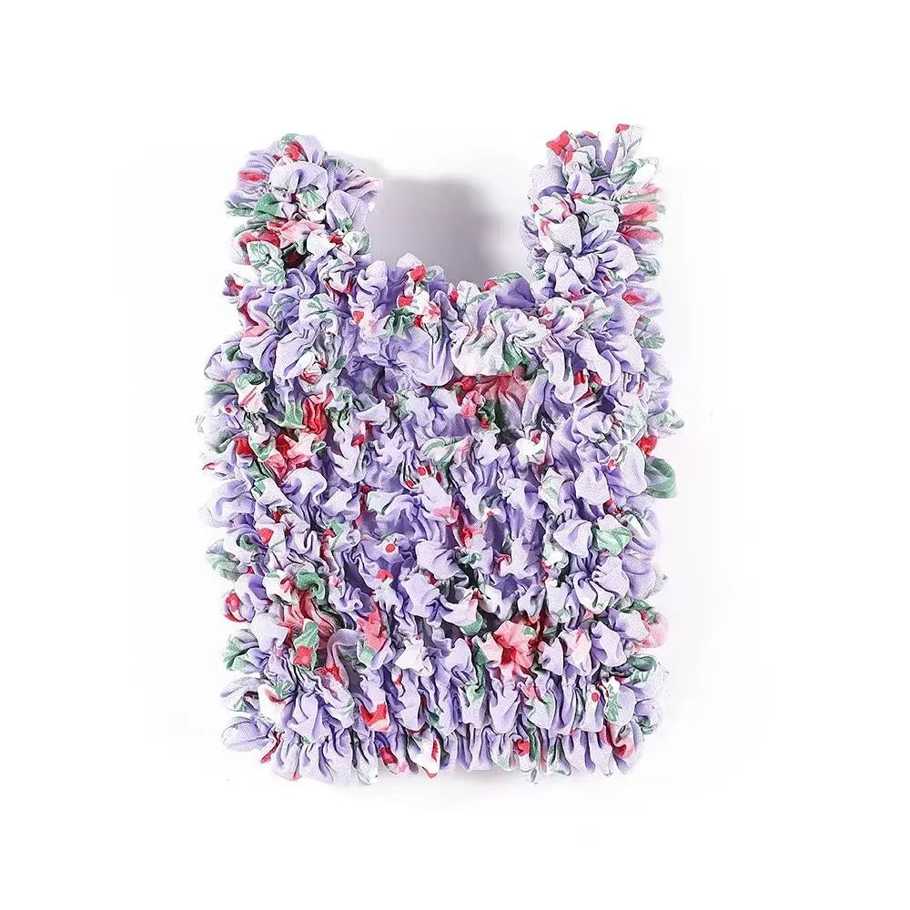 A reusable foldable bubble shopping bag made of ruffled purple and pink fabric.