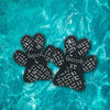 Black anti-slip paw protectors for dogs floating in clear blue water