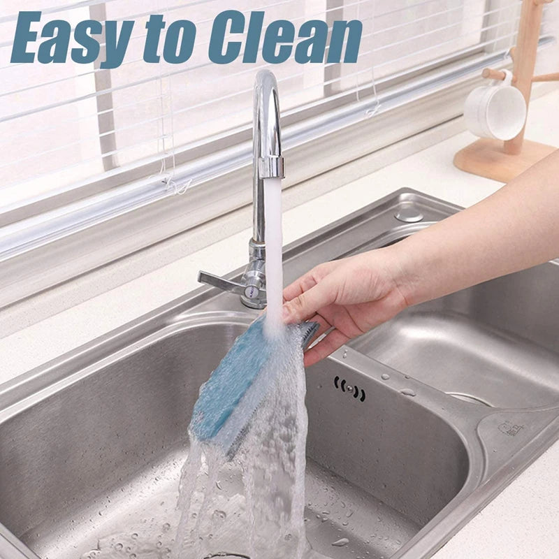 A hand is using a faucet to rinse a blue brush in a stainless steel kitchen sink, demonstrating easy cleaning.