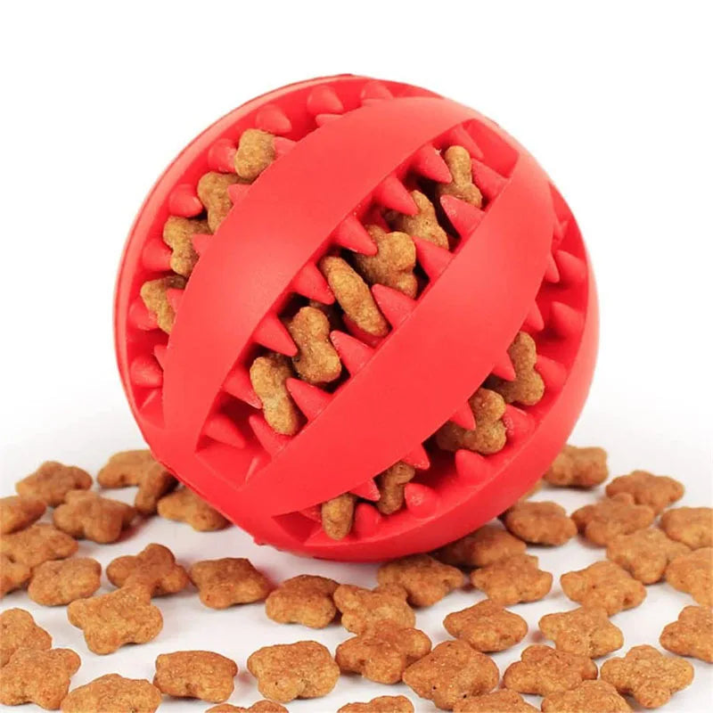 A bright red rubber ball filled with small, brown dog treats.