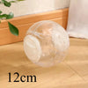 A clear plastic ball used for hamster exercise and play resting on a wooden surface.