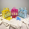 A collection of handcrafted mini house-shaped bags in yellow, pink, and blue, each featuring a puppy keychain charm.