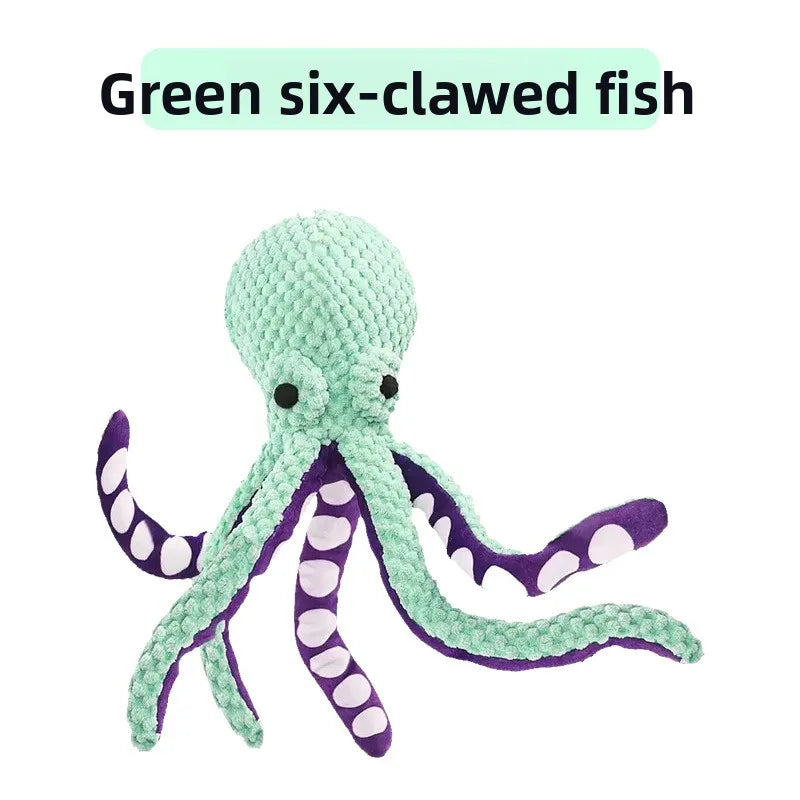 A green six-clawed fish plush toy with purple accents.