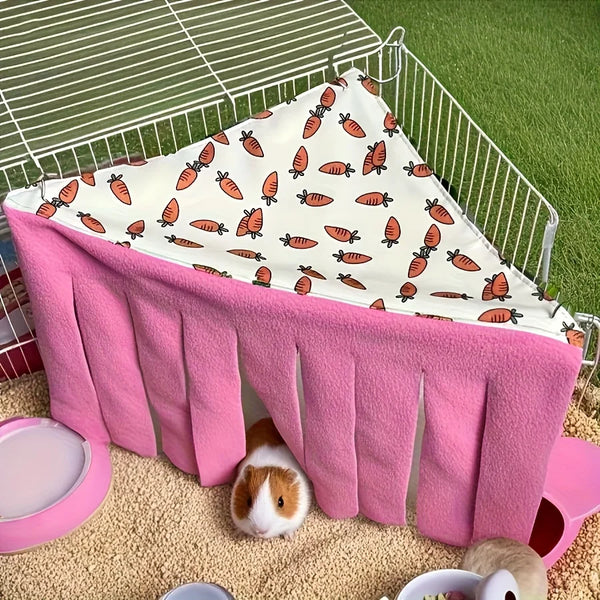 A pink washable pet hideaway hammock tent with orange and green patterned fabric is displayed on a green surface.