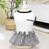 A white short-sleeved top with a black collar and a black and white checkered skirt displayed on a mannequin.