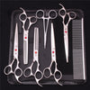 A set of professional stainless steel pet grooming scissors and combs displayed on a black case.