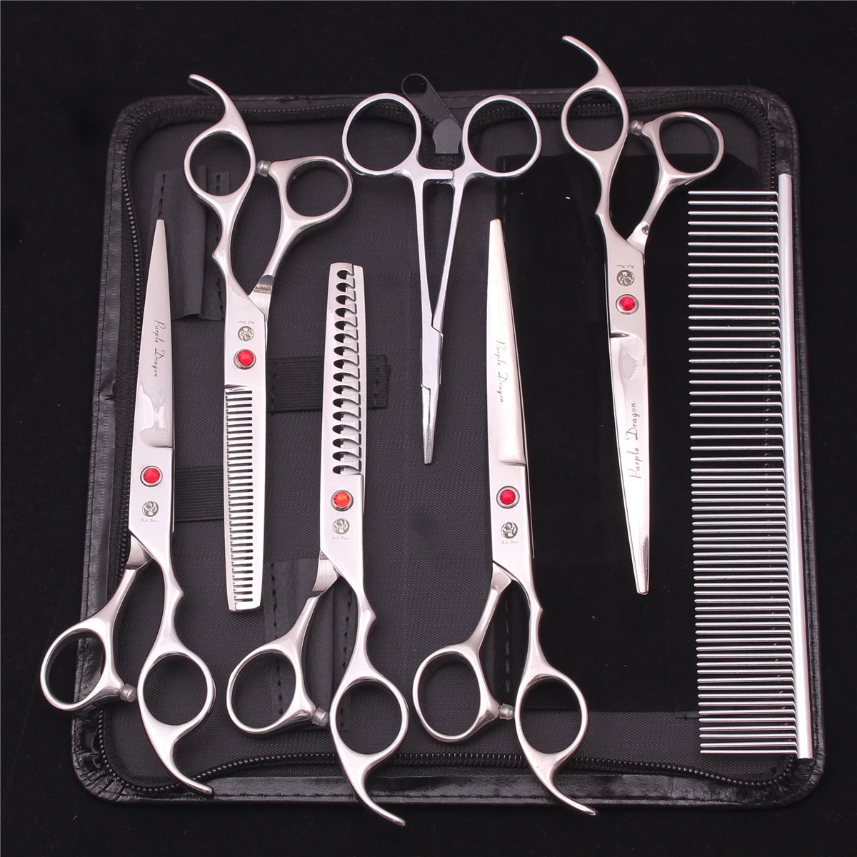 A set of professional stainless steel pet grooming scissors and combs displayed on a black case.