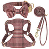 A set of classic plaid dog collar, harness, and leash with a bowtie in maroon and brown tones.