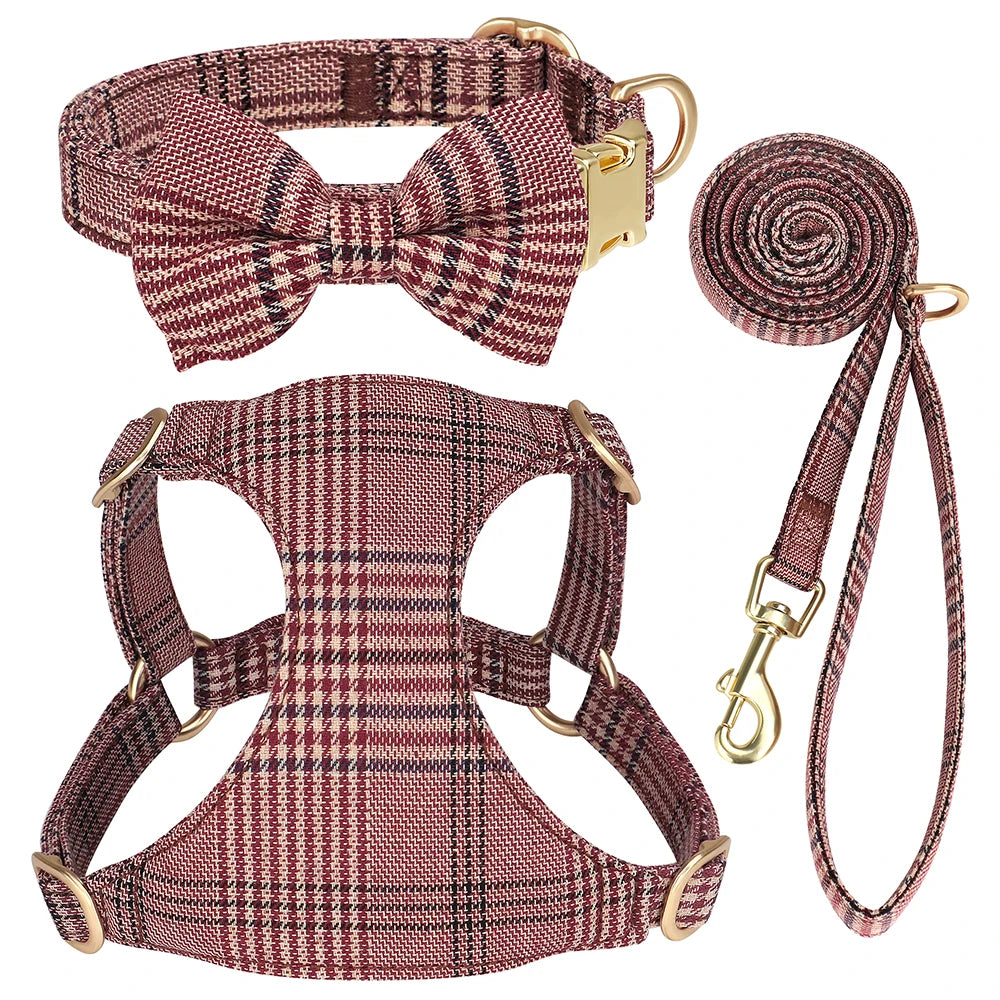 A set of classic plaid dog collar, harness, and leash with a bowtie in maroon and brown tones.