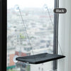 Schwarzes Fenster-Hängemöbel für Katzen, suspendiert in einem Fenster, vor einer städtischen Skyline.